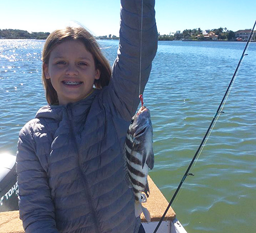 Girl holding her catch out in the Sarasota Intercoastal Waterway
