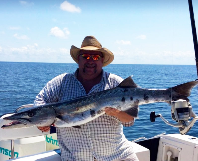 Gentleman sitting in the boat holding a large fish